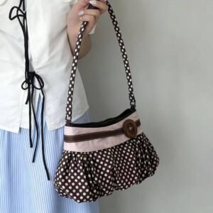 Brown and white polka dot Y2K shoulder bag with pink ribbon and large button detail.